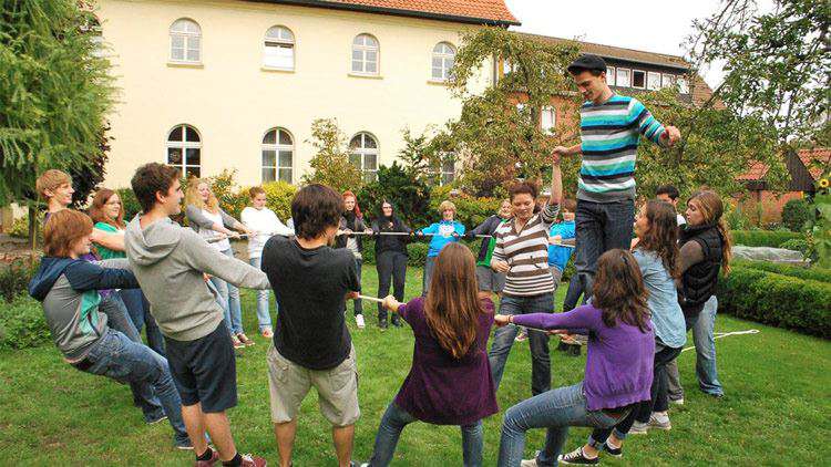  Eine Gruppe Jugendlicher steht in einem Kreis